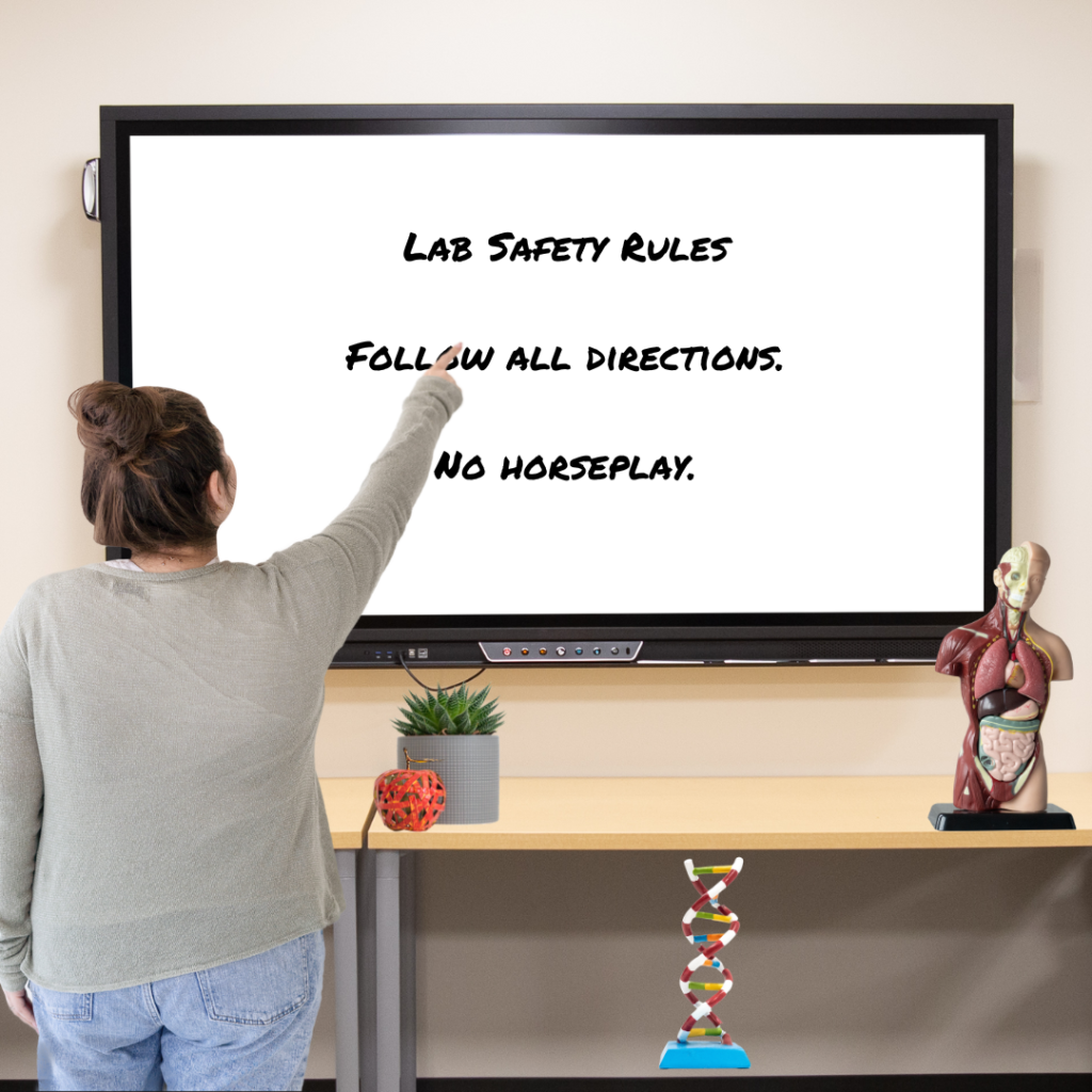 teacher pointing to lab safety on whiteboard